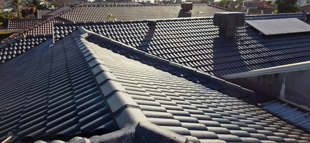After: restored charcoal tiled roof with ridge and hip capping, evaporative cooler and solar panel in Sydenham