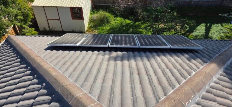 Before: weathered grey tiled roof with five solar panels in Sydenham
