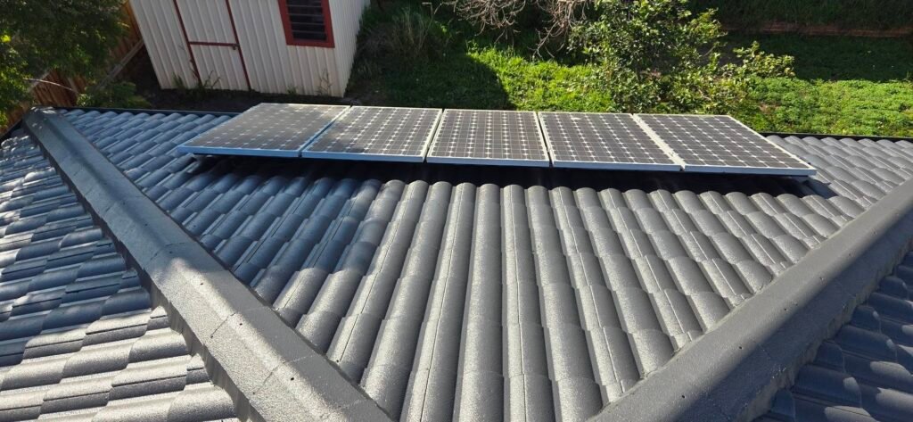 After: charcoal restored roof tiles beside solar panels in Sydenham