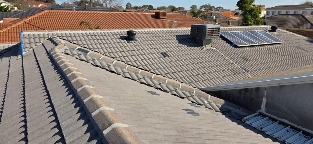 Before: faded tiled roof with whirlybird vent, evaporative cooler and solar panel in Sydenham
