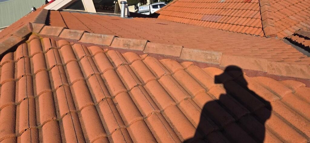 Before: aged ridge pointing on a tiled roof in Hillside